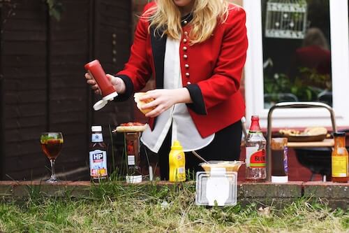 woman in a red jacket making a burger for memorial day bbq